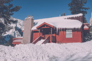 Red house covered with snow and icicles in a cold winter landscape