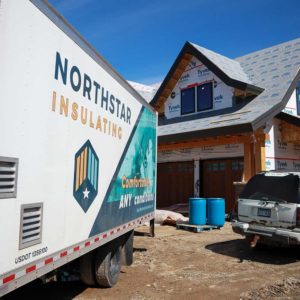 Northstar truck parked beside a house that is getting insulated